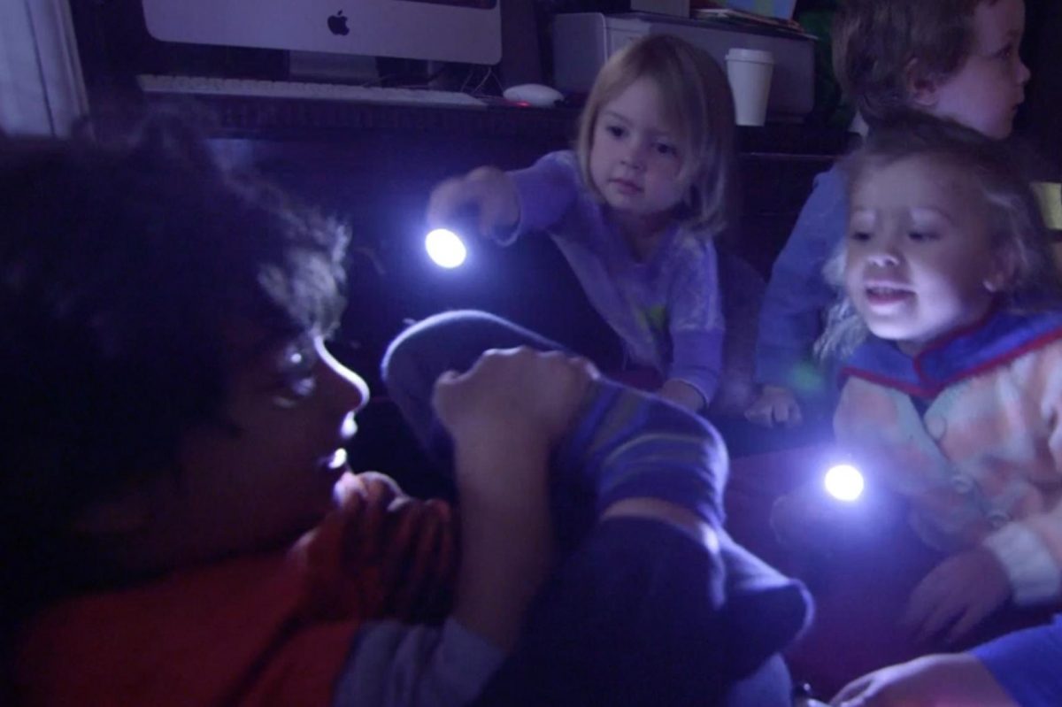 Group of kids playing in the dark with flashlights