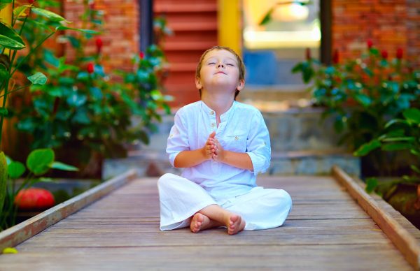 cute boy trying to find inner balance in meditation
